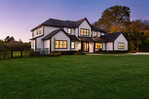 a front view of a house with a garden and yard