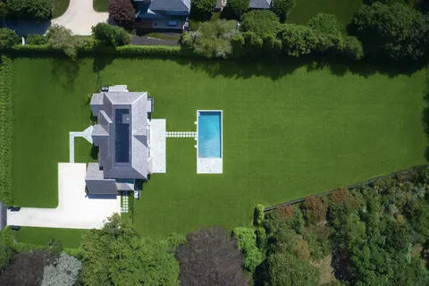 an aerial view of a house with a garden and lake view