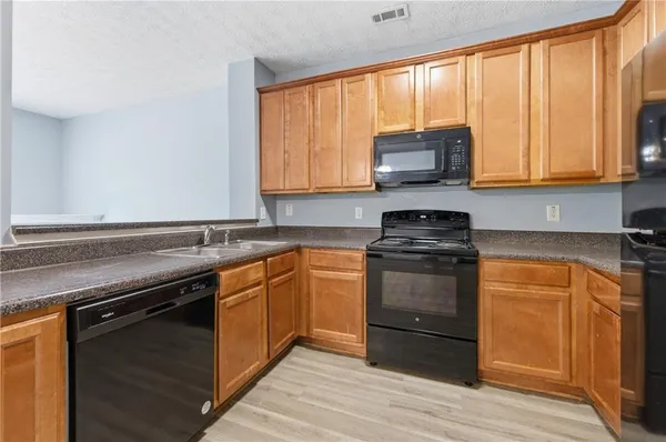 a kitchen with stainless steel appliances granite countertop a stove a sink and a microwave