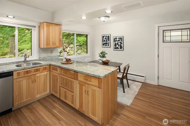 a kitchen with a sink stove and wooden floor