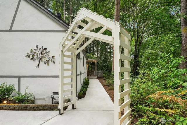 a view of a white house with large windows and a small yard