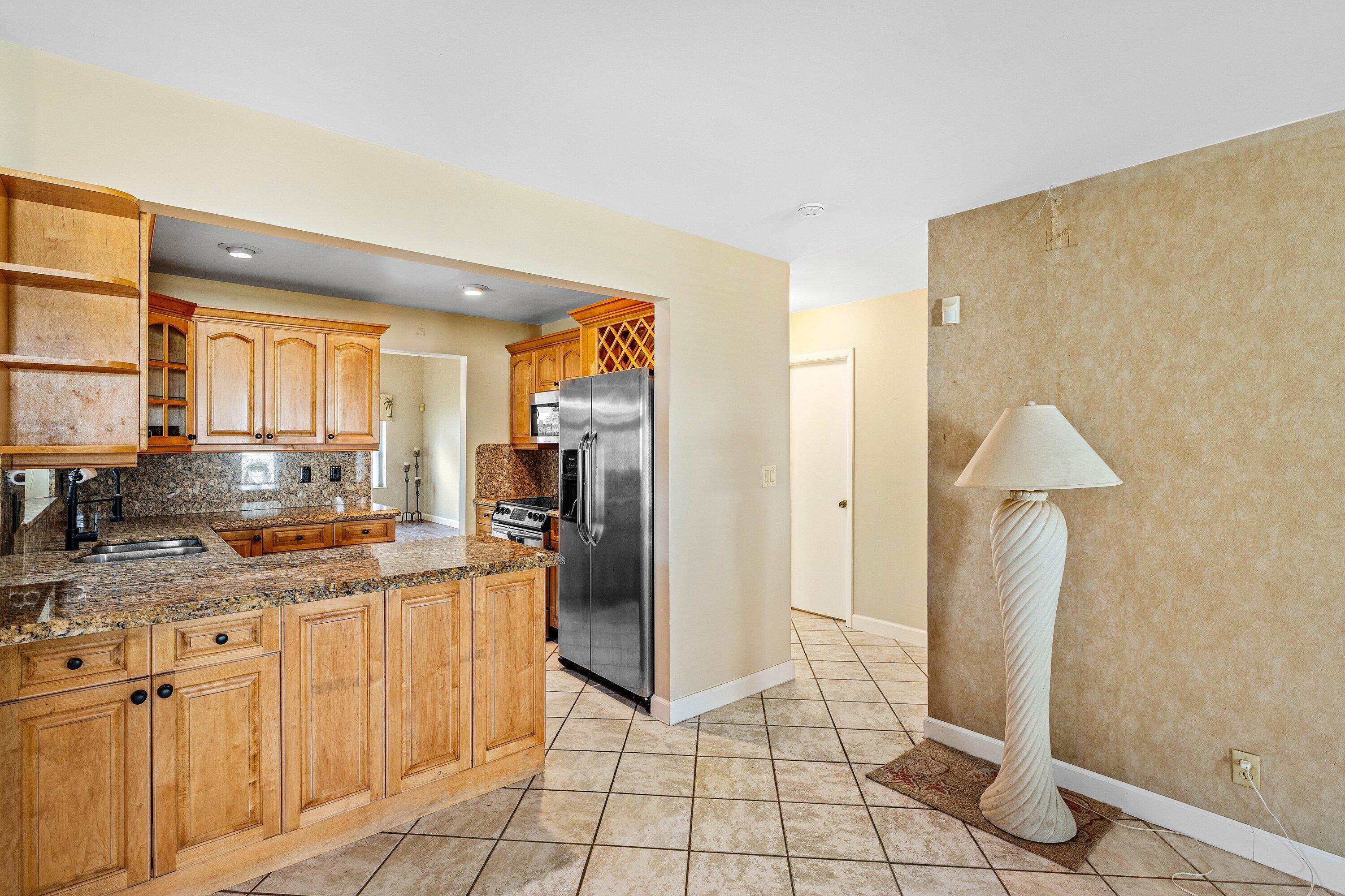 3068 Northwest 25th Way Boca Raton, FL 33434 - Photo 11 of 43 a kitchen with stainless steel appliances granite countertop a refrigerator and a sink