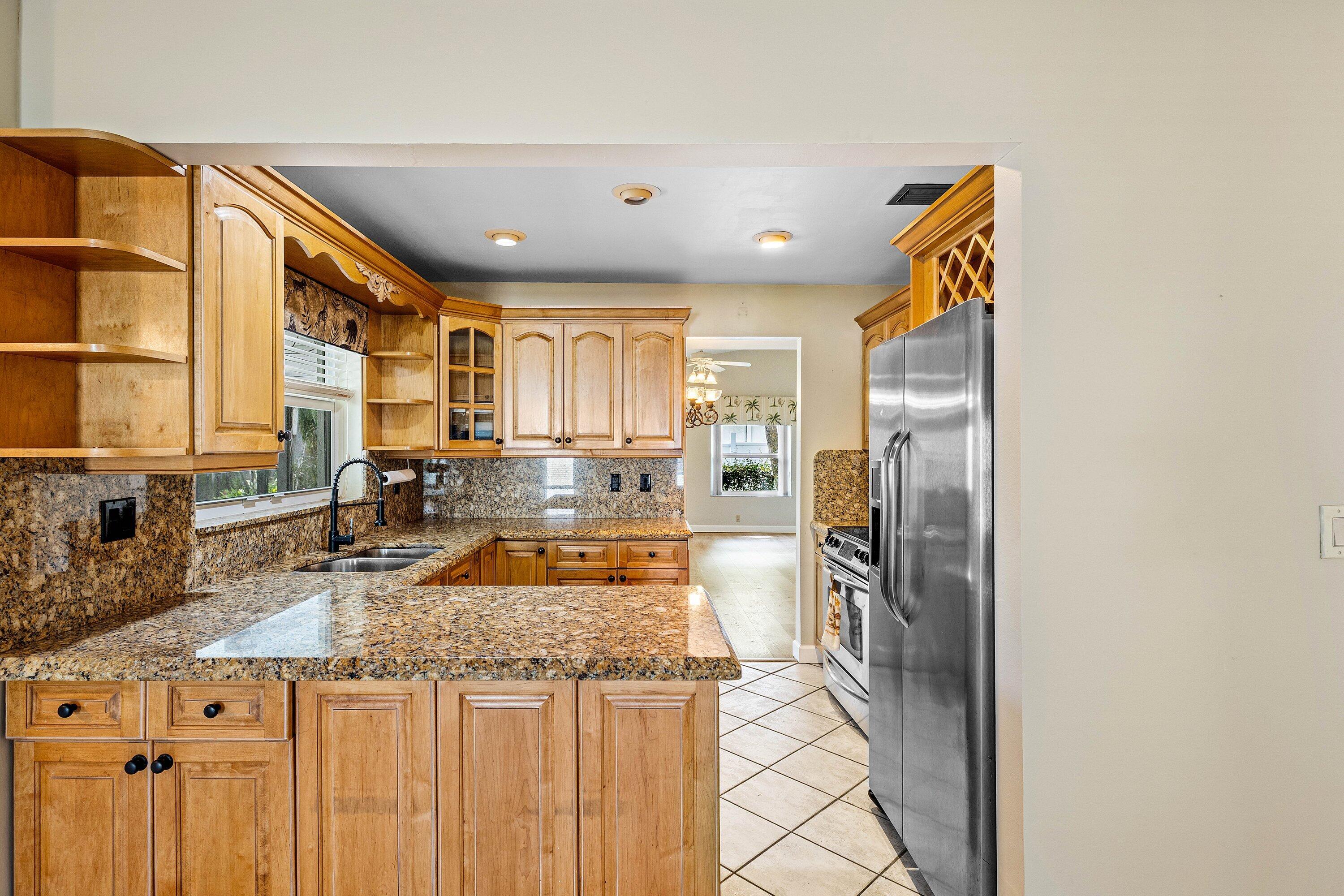 3068 Northwest 25th Way Boca Raton, FL 33434 - Photo 13 of 43 a kitchen with stainless steel appliances granite countertop a sink and a refrigerator