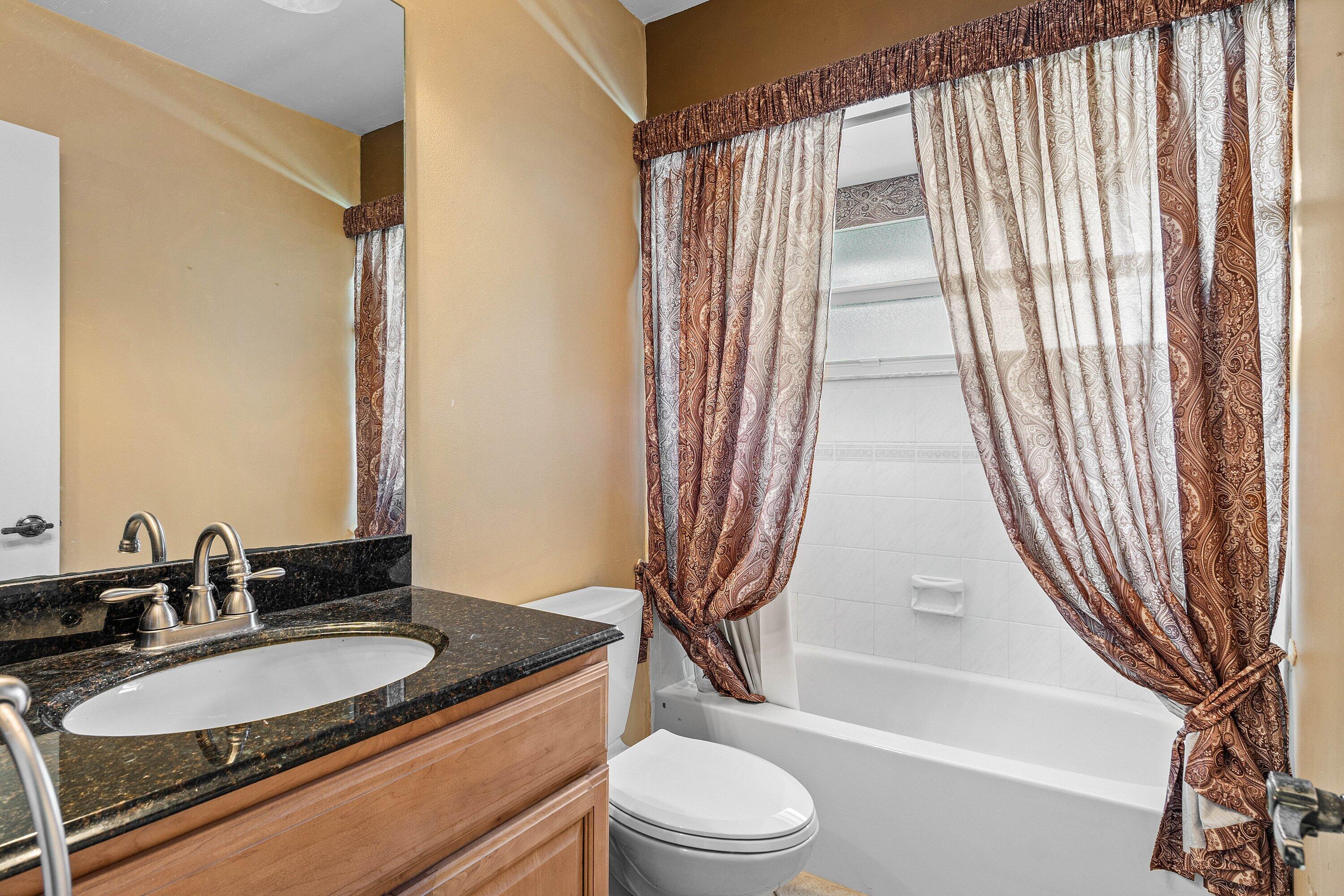 3068 Northwest 25th Way Boca Raton, FL 33434 - Photo 19 of 43 a bathroom with a granite countertop sink toilet and shower