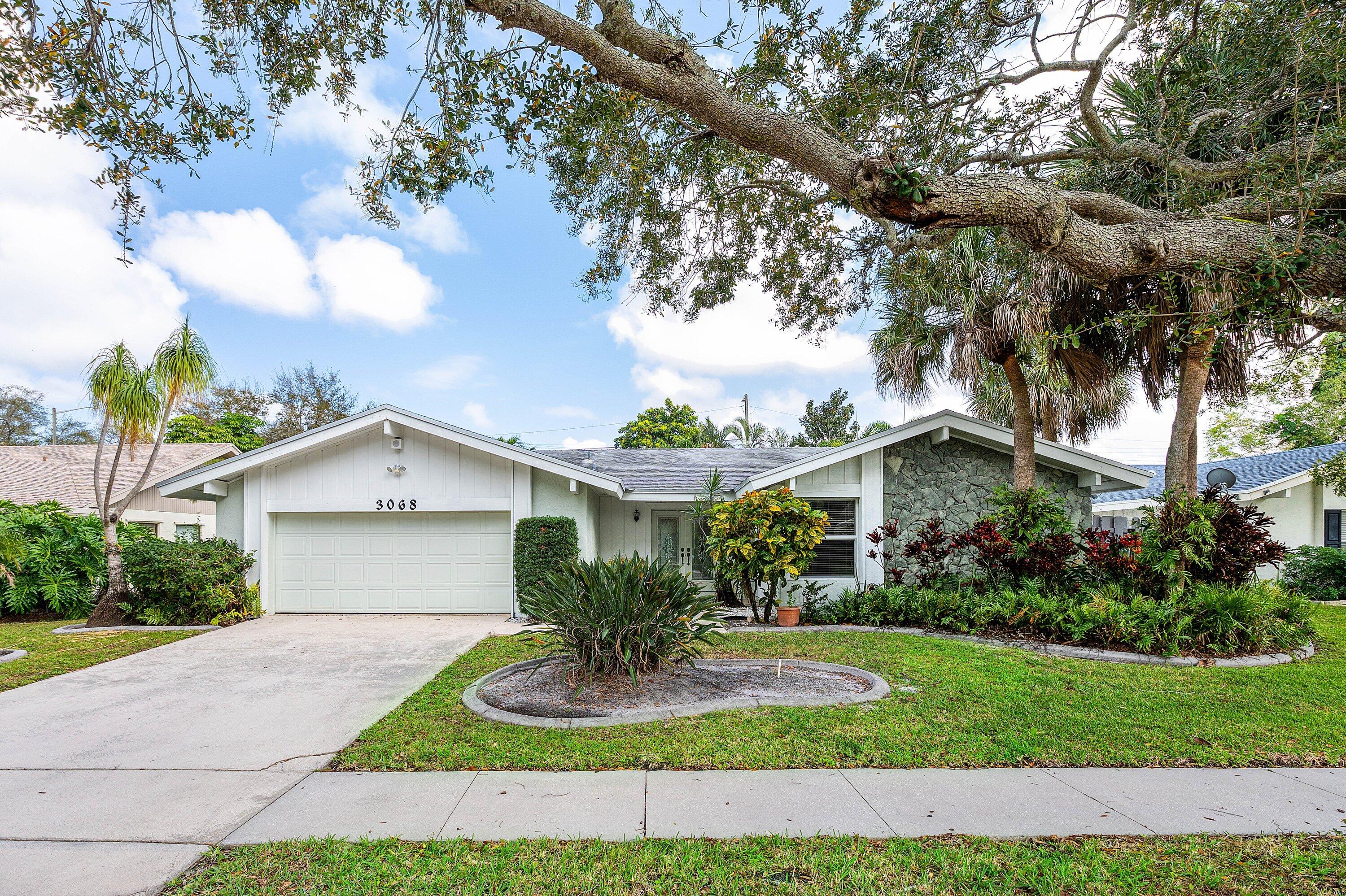 3068 Northwest 25th Way Boca Raton, FL 33434 - Photo 2 of 43 a view of house with a yard and potted plants