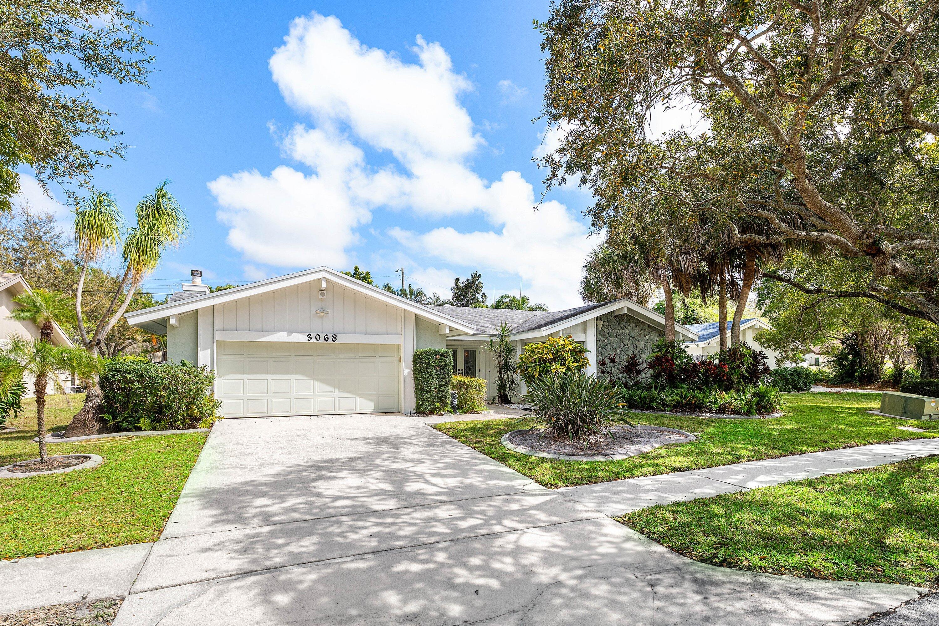 3068 Northwest 25th Way Boca Raton, FL 33434 - Photo 33 of 43 a front view of a house with garden