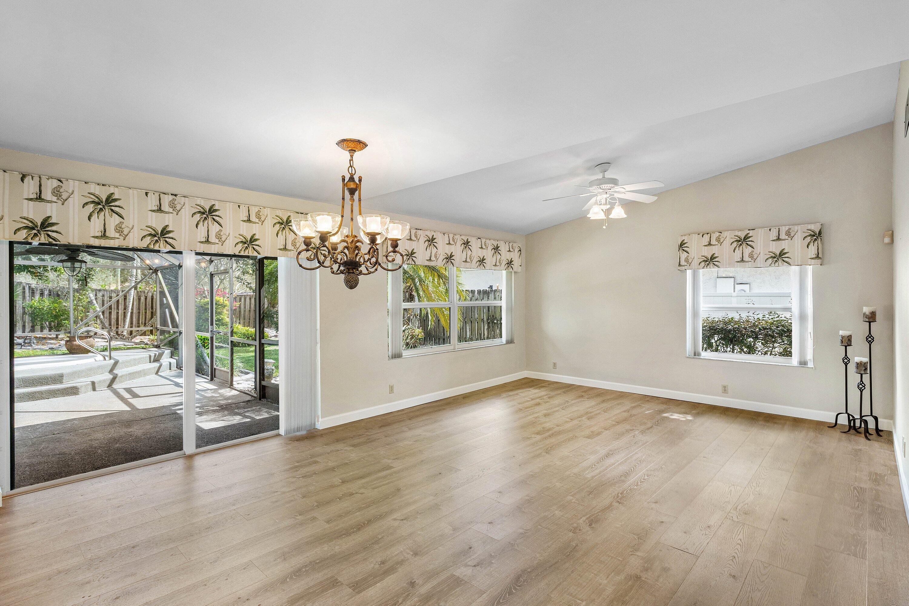 3068 Northwest 25th Way Boca Raton, FL 33434 - Photo 5 of 43 a view of a livingroom with wooden floor windows and a chandelier