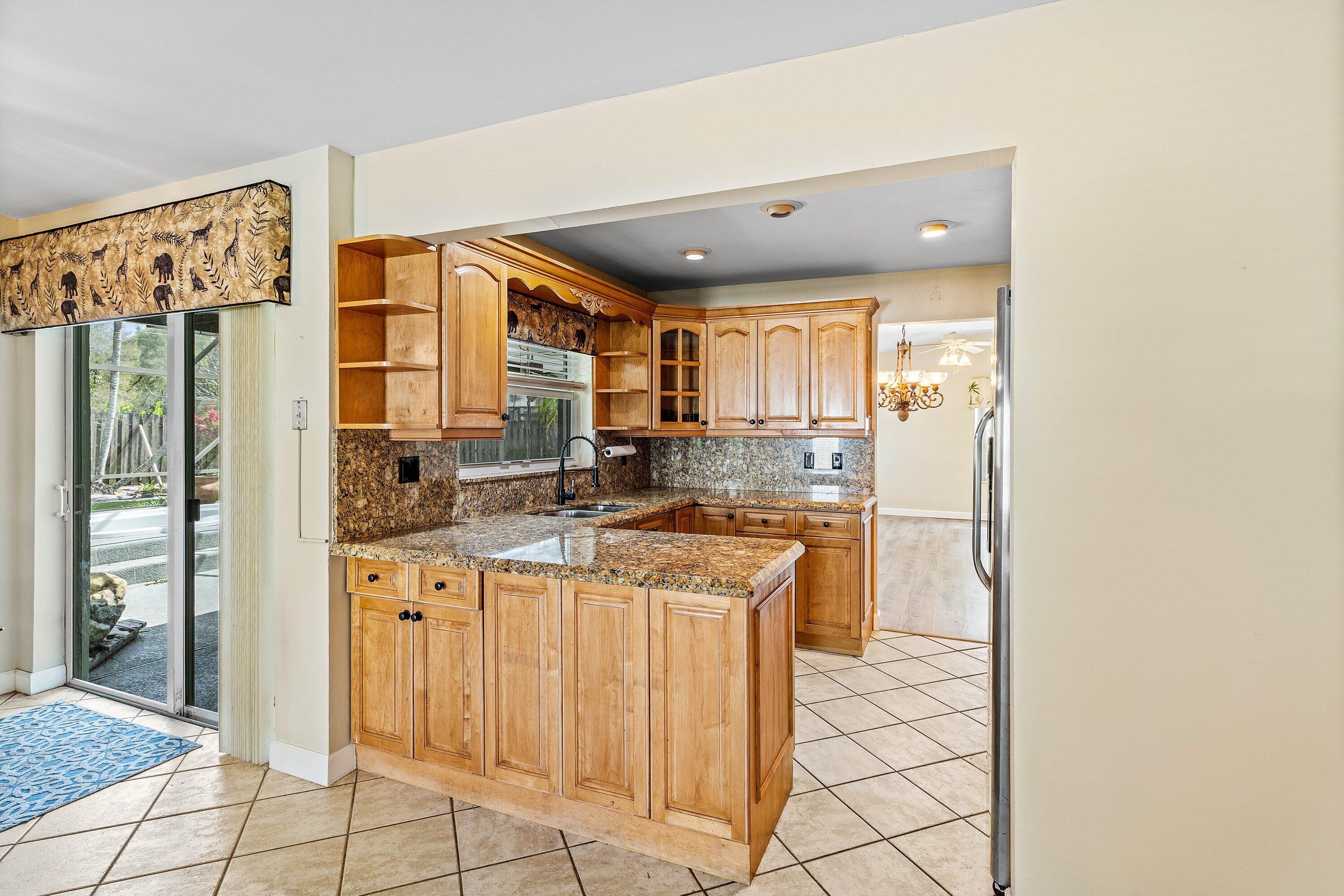 3068 Northwest 25th Way Boca Raton, FL 33434 - Photo 10 of 43 a kitchen with stainless steel appliances granite countertop a refrigerator and a sink