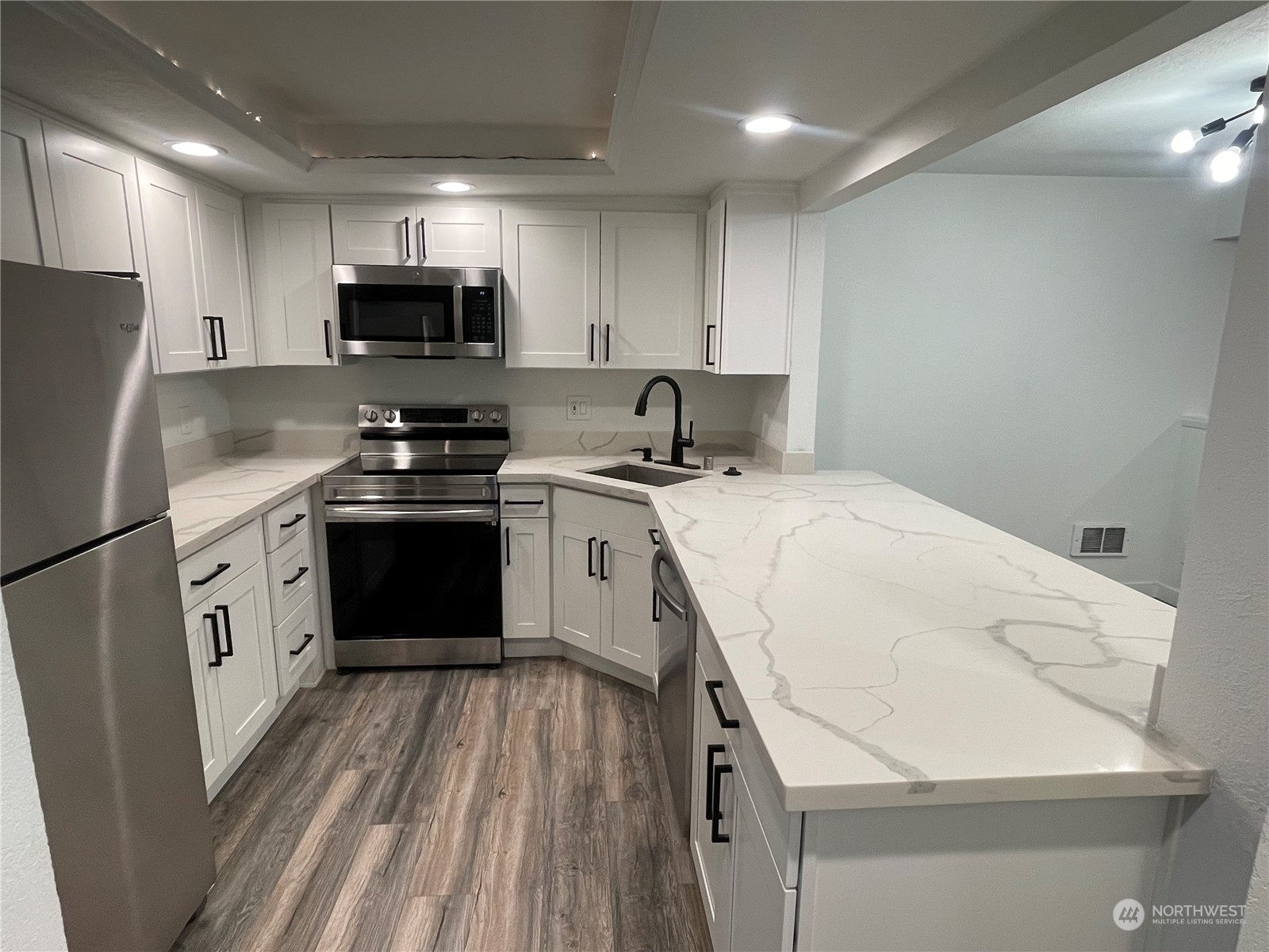 2613 Northeast 4th Street, Unit 221 Renton, WA 98056 - Photo 9 of 31 a kitchen with a sink a stove a microwave and cabinets