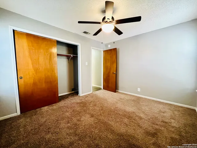a view of empty room with ceiling fan