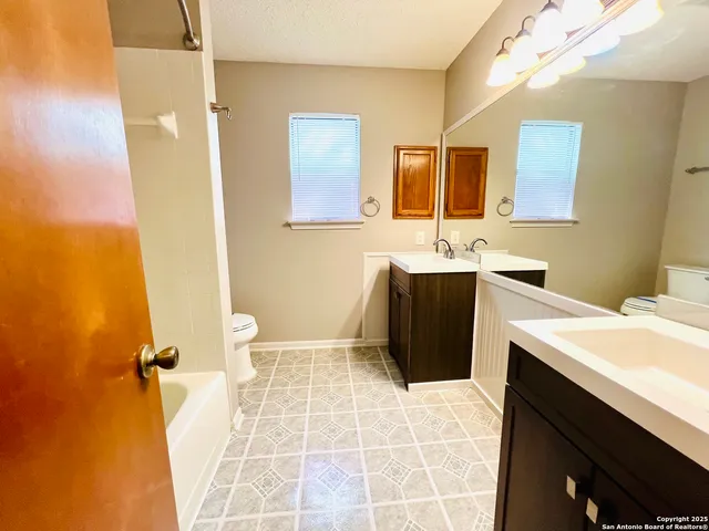 a bathroom with a sink a toilet and mirror