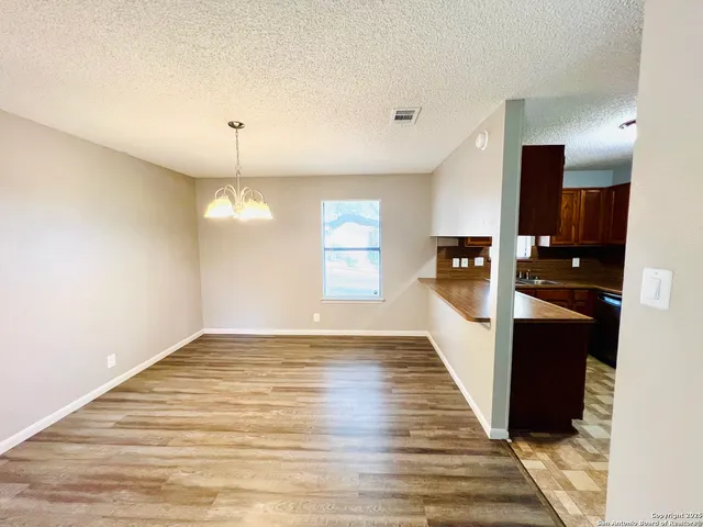 a view of a living room a kitchen with wooden floor and kitchen