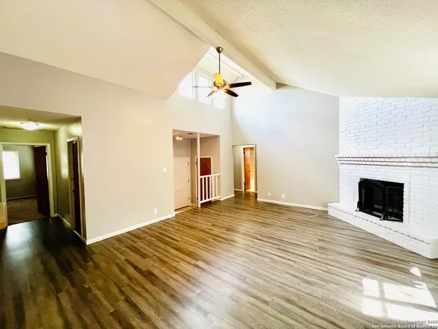 a view of a livingroom with wooden floor and a fireplace
