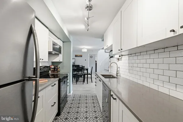 a kitchen with granite countertop a sink a counter top space appliances and cabinets