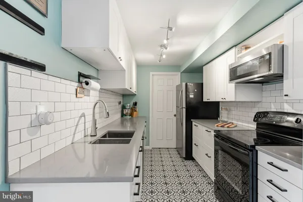 a kitchen with stainless steel appliances granite countertop a sink a stove and a refrigerator