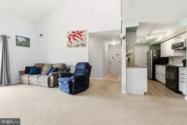 a living room with furniture and kitchen view