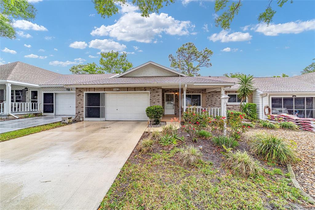 9240 Southwest 90th Court, Unit B Ocala, FL 34481 - Photo 1 of 40 a front view of a house with a garden