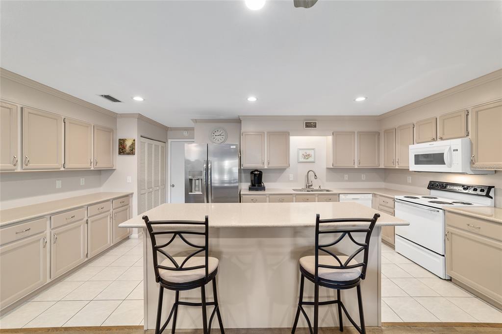9240 Southwest 90th Court, Unit B Ocala, FL 34481 - Photo 18 of 40 a kitchen with stainless steel appliances kitchen island granite countertop a stove a sink a table and chairs in it