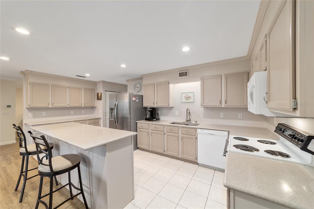 9240 Southwest 90th Court, Unit B Ocala, FL 34481 - Photo 19 of 40 a kitchen with kitchen island a stove a table and chairs in it