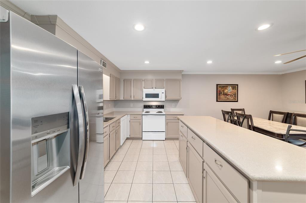 9240 Southwest 90th Court, Unit B Ocala, FL 34481 - Photo 20 of 40 a large kitchen with a large counter top appliances and cabinets