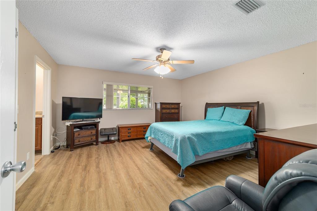 9240 Southwest 90th Court, Unit B Ocala, FL 34481 - Photo 28 of 40 a bedroom with a bed and a flat screen tv