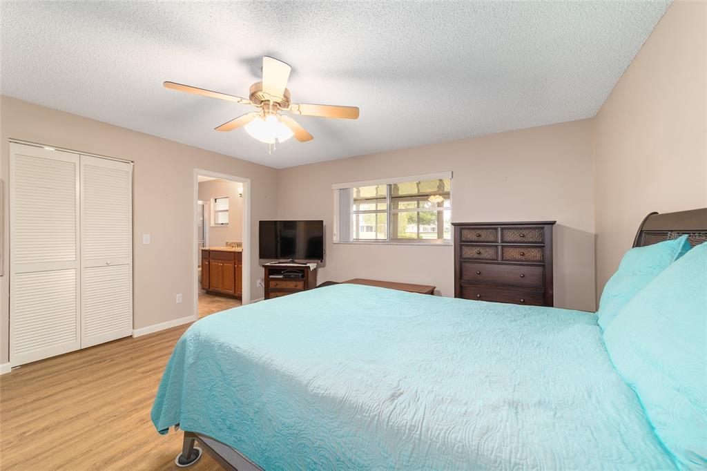 9240 Southwest 90th Court, Unit B Ocala, FL 34481 - Photo 29 of 40 a bedroom with a bed and a flat tv screen on dresser