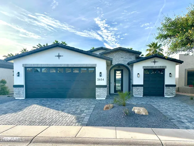 a view of a house with a yard and large tree