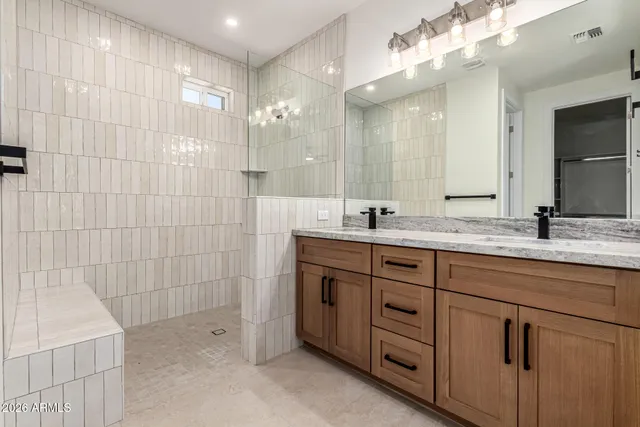 a bathroom with a double vanity sink mirror and shower