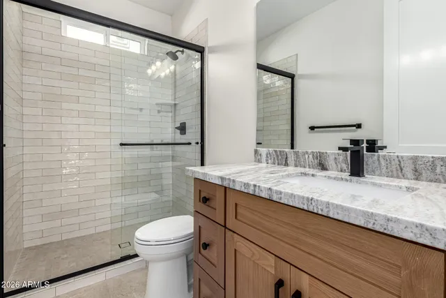a bathroom with a granite countertop sink toilet and shower