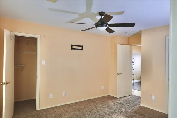 a view of a hallway with a ceiling fan
