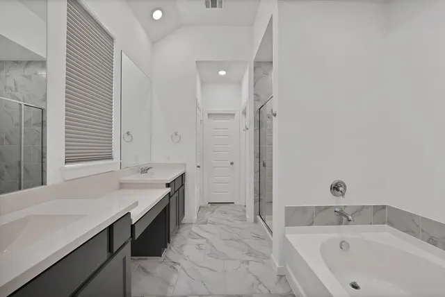 a bathroom with a tub sink and mirror