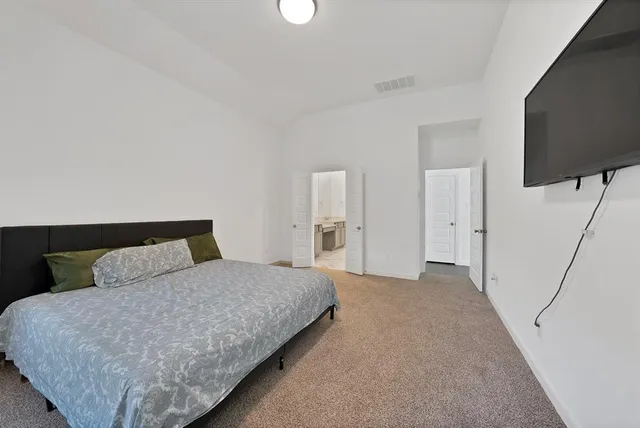 a bedroom with a bed and a flat screen tv