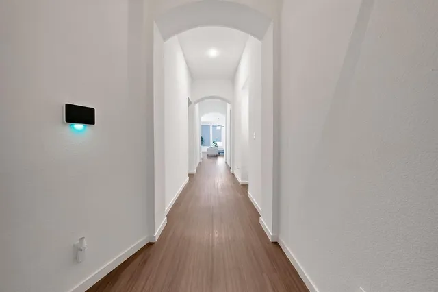 a view of a hallway with wooden floor