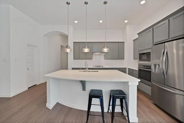 a kitchen with kitchen island a sink stove and refrigerator