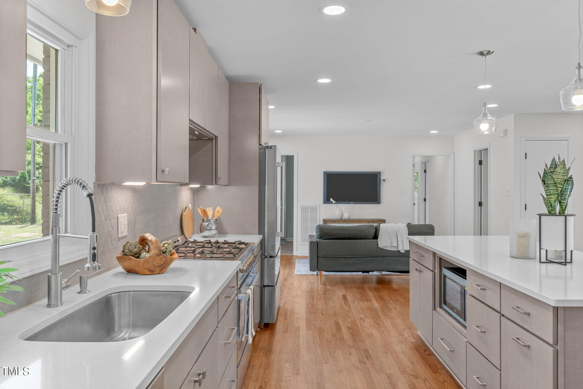 612 Delany Drive Raleigh, NC 27610 - Photo 13 of 45 a large kitchen with stainless steel appliances a large counter top a sink and a refrigerator