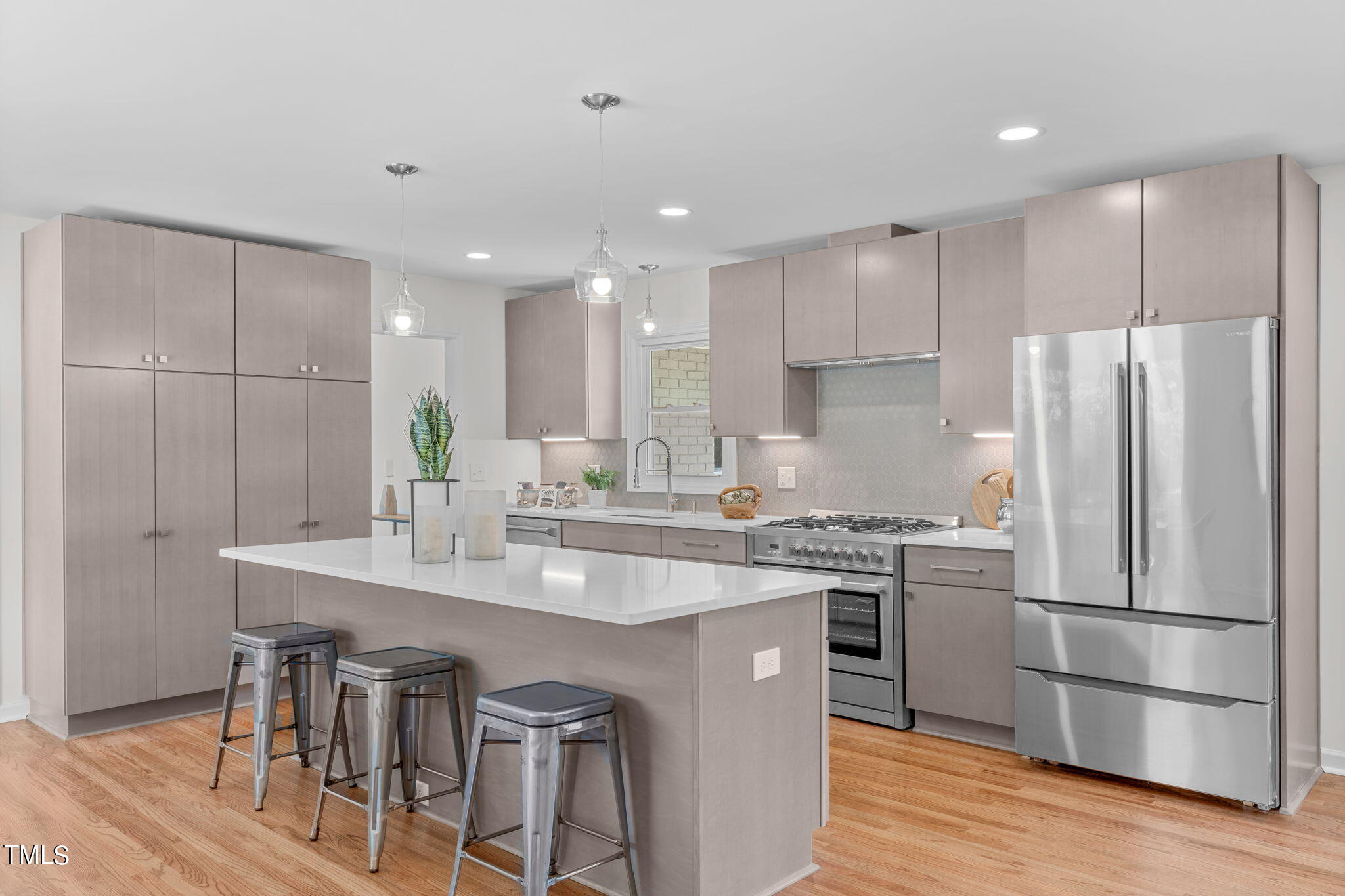 612 Delany Drive Raleigh, NC 27610 - Photo 10 of 45 a kitchen with kitchen island granite countertop a sink a stove a refrigerator and white cabinets with wooden floor