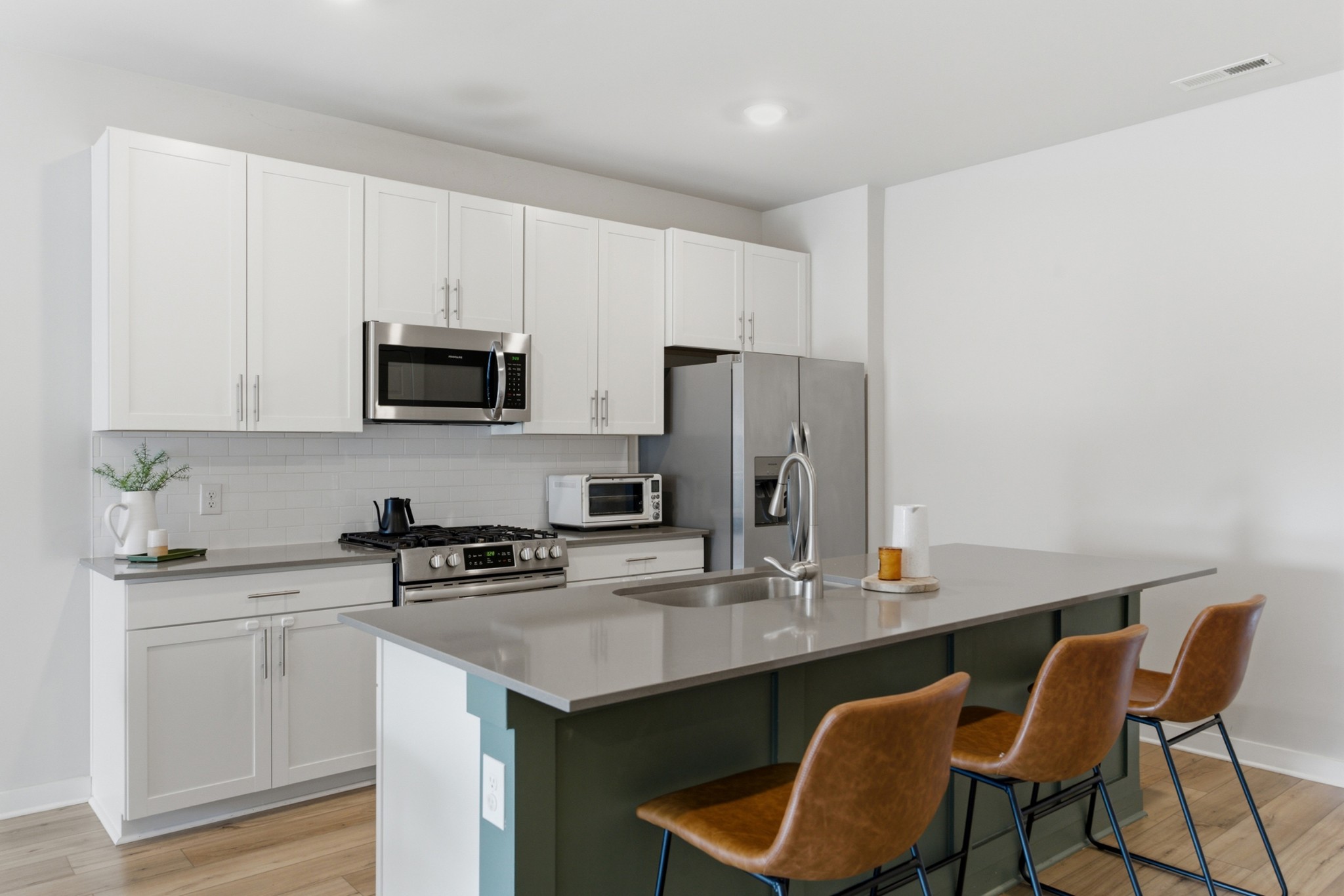 165 Harvest Point Boulevard Spring Hill, TN 37174 - Photo 8 of 28 a kitchen with stainless steel appliances a sink a stove a refrigerator cabinets and dining table