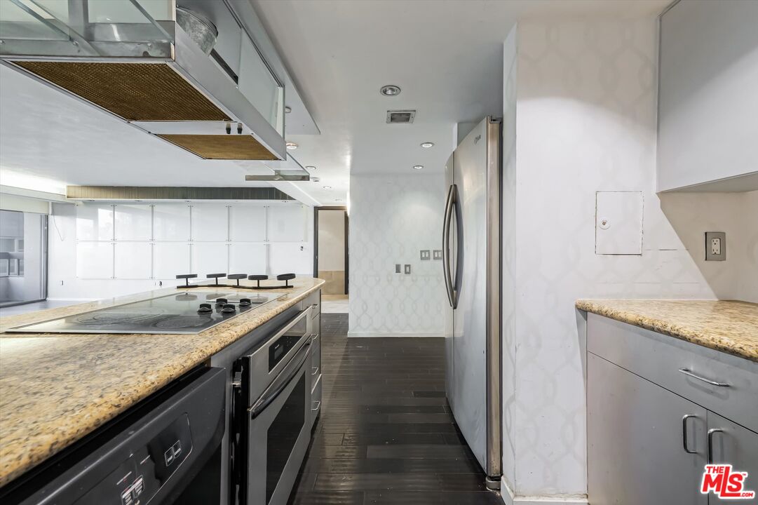 10590 Wilshire Boulevard, Unit 504 Los Angeles, CA 90024 - Photo 12 of 53 a kitchen with granite countertop a sink and a stove