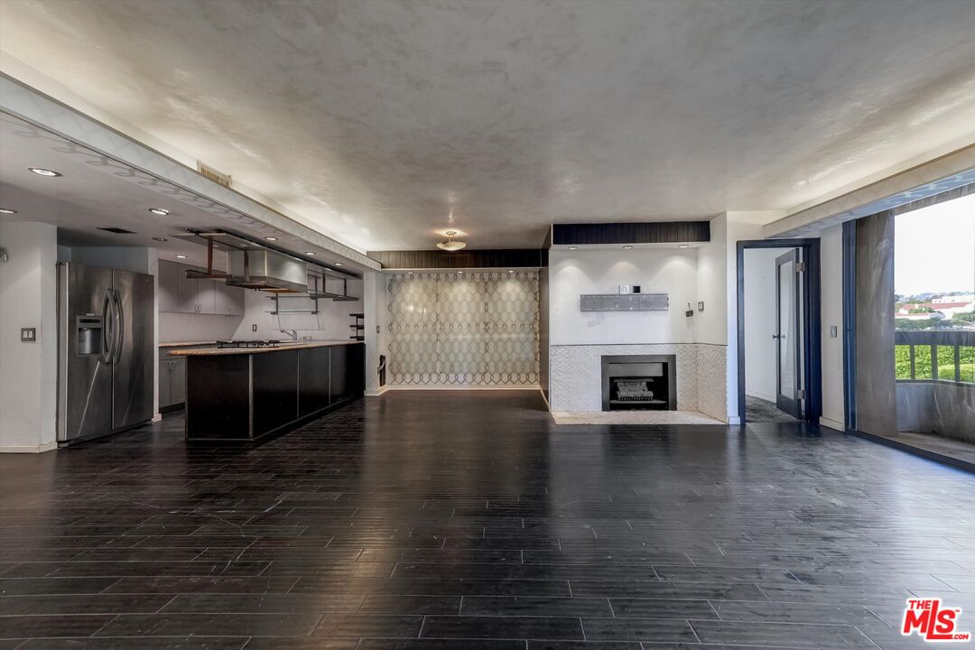 10590 Wilshire Boulevard, Unit 504 Los Angeles, CA 90024 - Photo 17 of 53 an empty room with wooden floor fireplace and windows