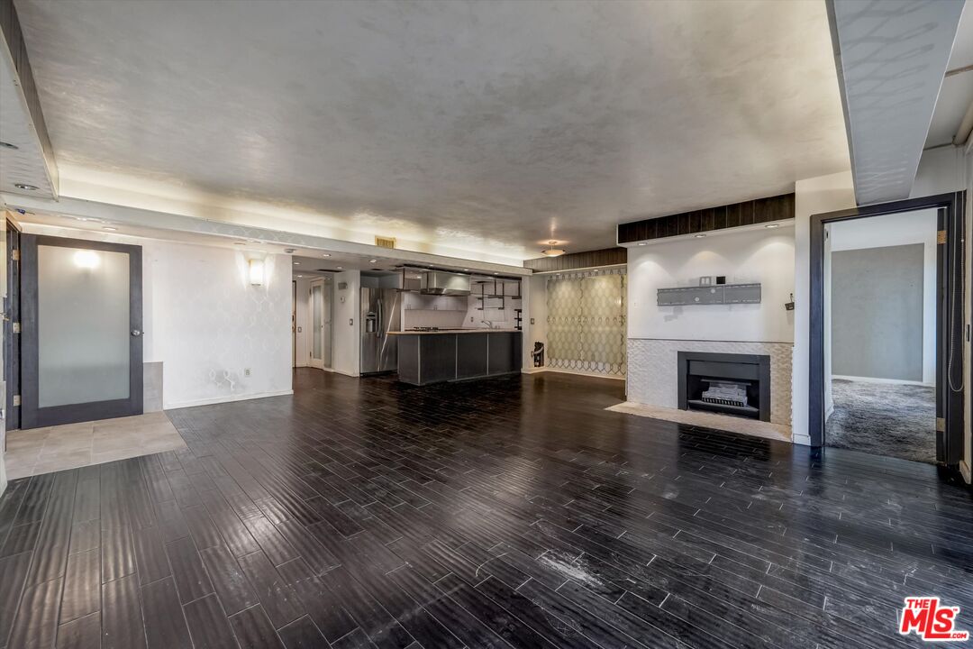 10590 Wilshire Boulevard, Unit 504 Los Angeles, CA 90024 - Photo 18 of 53 an empty room with wooden floor a fireplace