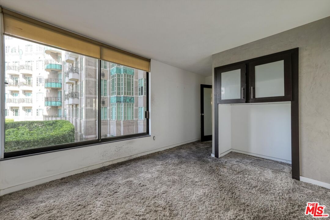 10590 Wilshire Boulevard, Unit 504 Los Angeles, CA 90024 - Photo 27 of 53 a view of an empty room with wooden floor and a window