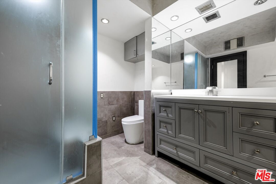 10590 Wilshire Boulevard, Unit 504 Los Angeles, CA 90024 - Photo 39 of 53 a bathroom with a toilet a sink and mirror