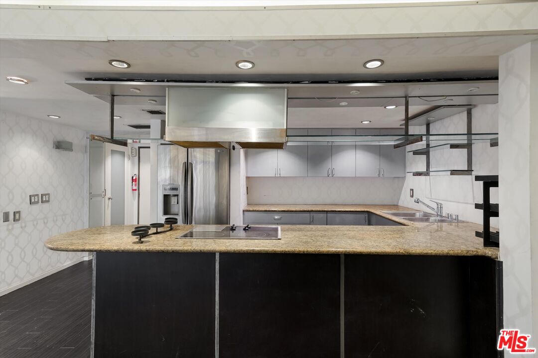10590 Wilshire Boulevard, Unit 504 Los Angeles, CA 90024 - Photo 8 of 53 a kitchen with a sink a stove and cabinets