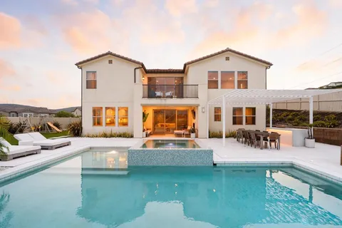 a view of a house with swimming pool and sitting area