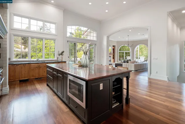 a kitchen with stainless steel appliances granite countertop a stove and a large window