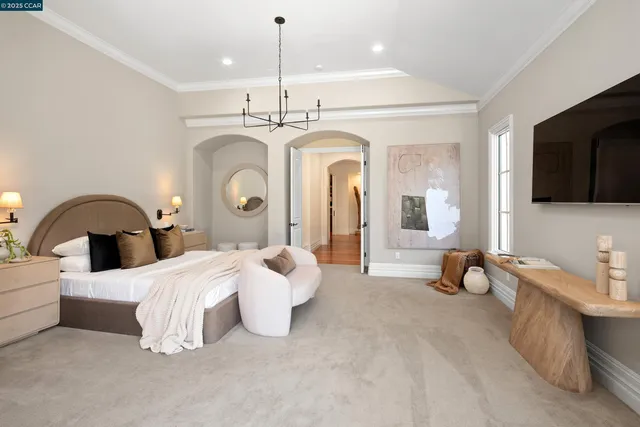 a bedroom with bed and a chandelier