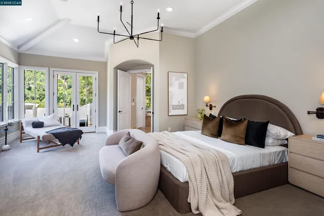 a bedroom with a bed couch and a large window