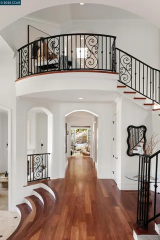 a view of a hallway with wooden floor and staircase