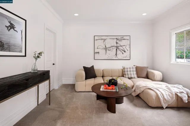 a living room with furniture and a painting on the wall