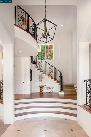 a view of staircase with white walls and a chandelier
